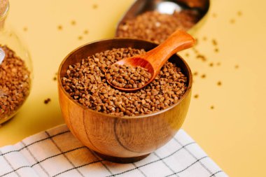 Karabuğday ahşap bir kasede inliyor. Sıcak bir mutfak ortamında pişirmeye ya da servis etmeye hazır.