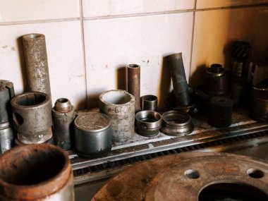 Aletler ve metal parçalar gün içinde bir atölyede bir tezgah üzerinde düzenlenir