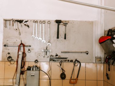 Parlak ve düzenli bir garaj ortamında atölye duvarında düzenlenmiş araçlar