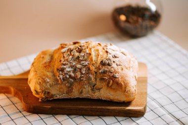 Tahtada karpuz tohumlarıyla kaplı taze ekmek servis edilmeye hazır.