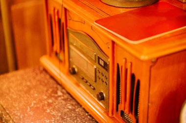 Kaliteli ahşap radyo, yumuşak ışıkla aydınlatılmış sıcak, rahat bir odada, masanın üzerinde duruyor.