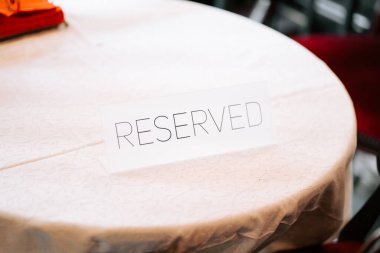 Konuklar gelmeden önce yemek salonunda önemli bir etkinlik için masa ayırtıldı.