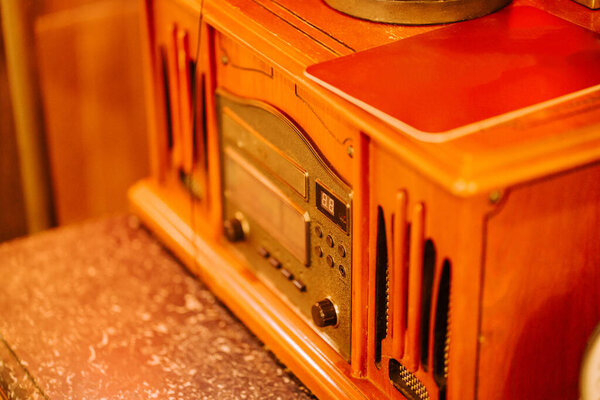 Винтажное деревянное радио, сидящее на столе в теплой, уютной комнате, освещенной мягким светом