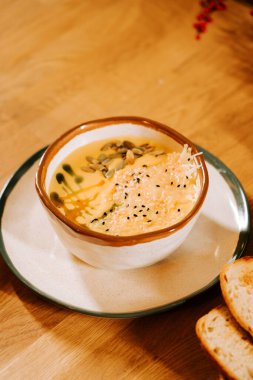 Kremalı çorba, şifalı otlar ve ekmek ile servis edilir kırsal ahşap bir masada.