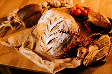 Mevsimlik malzemeler ve sıcaklıkla çevrili taze pişmiş zanaatkar ekmeği.