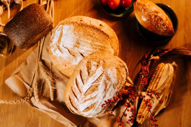 Köy dekorlu taze zanaatkar ekmeği ve ahşap masa üzerinde doğal elementler.