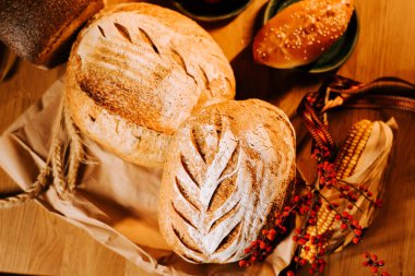 Sıcak bir kafe ortamında doğal elementlerle sergilenen taze zanaatkar ekmeği.
