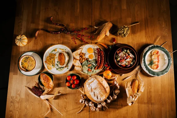Mevsimlik yemekler ve ahşap bir masada canlı malzemelerle nefis bir sonbahar ziyafeti.