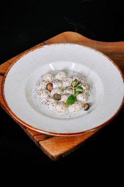 Süslü bir kasede servis edilen kremalı ve süslemeli tatlı.