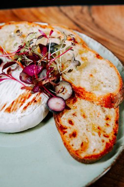 Lezzetli krem peynir, kızarmış ekmek ve lezzetli bir aperatif için taze otlarla servis edilir.