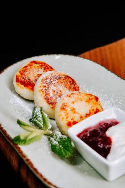 Köy tabaklarında reçel ve ekşi kremayla servis edilen leziz peynirli krepler.