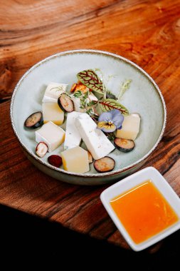 Tahta masada peynir, meyve ve sos ile eşsiz bir tatlı sunumu