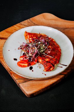 Tahta tabakta taze domatesler ve mikroyeşilliklerle servis edilen lezzetli omlet.