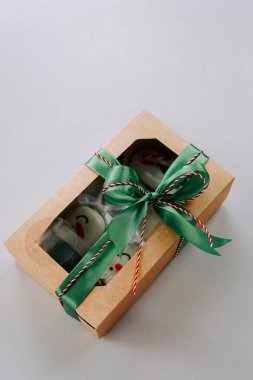 Tatil kutlamaları için yeşil kurdeleli gözlüklü hediye kutusu.