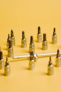 Açık görünürlük için sarı arkaplan üzerine çeşitli tornavida bitleri sıralanmış araç seti