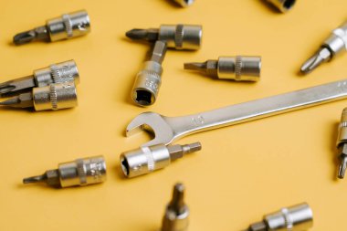 DIY projesi veya onarım etkinliği sırasında sarı bir yüzeye yerleştirilmiş araç ve bağlayıcılar