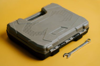 Ev onarım işleri ve bakım işleri için sarı arka planda ingiliz anahtarı olan alet çantası