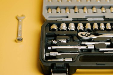 Tool set with socket and wrench on yellow surface