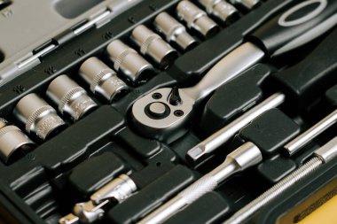 Tools are arranged neatly in a tool kit with various sockets and implements for repairs