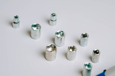 Araç tanımlama ve seçim için beyaz bir yüzeye yerleştirilmiş farklı boyutlarda metal soketler