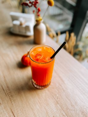 Öğleden sonra taze portakal suyu ve ahşap bir masa.