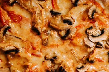 Yemek saatinde yerel bir restoranda servis edilen peynirli, tavuklu ve mantarlı pizza.