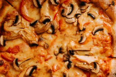 Peynirli, tavuklu ve mantarlı pizza öğle yemeğinde sıradan bir yemek ortamında servis edilir.