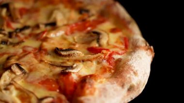 Sıcak bir mutfakta servis edilen peynirli, tavuklu ve mantarlı taze pişmiş pizza.