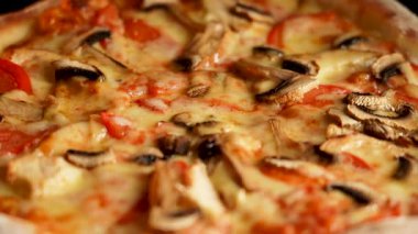 Peynirli, tavuklu ve mantarlı pizzanın tadını çıkarıyorum.