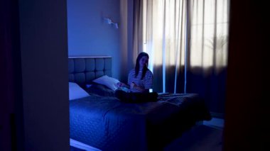 Kadın akşamları dizüstü bilgisayarın başında oturup müzik dinliyor.