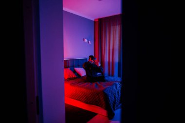 Genç bir kadın gece vakti yatak odasında sanal gerçeklik gözlüğü kullanıyor.