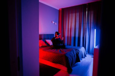 Akşam saatlerinde loş bir odada sanal gerçekliği keşfeden genç bir kadın.