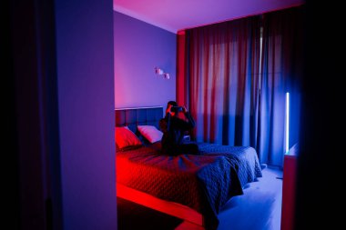 Gece karanlık bir odada sanal gerçeklik gözlüğü takan genç bir kadın.