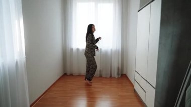 Kadınlar sabah vakti evde leopar desenli pijamalarıyla dans eder.