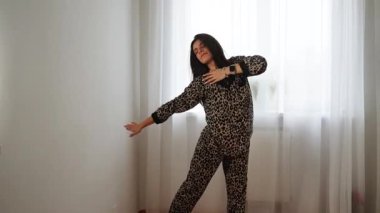Kadınlar gün içinde evde leopar desenli pijamalarıyla dans eder.