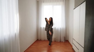 Kadınlar öğleden sonra evde leopar desenli pijamalarıyla dans eder.