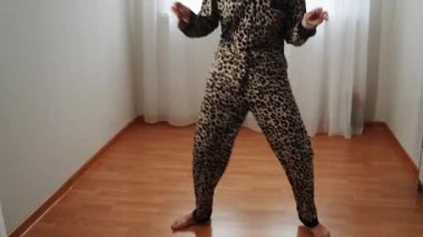 Kadınlar eğlence ve egzersiz için evde leopar desenli pijamalarıyla dans eder.