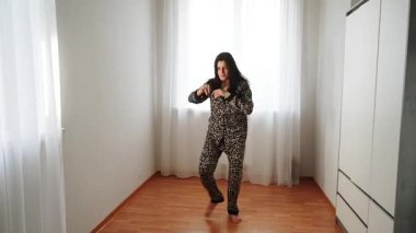 Kadınlar gün boyunca evde leopar desenli pijamalarıyla dans eder.