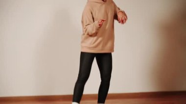 Kadın dans salonunda dans eder, akşam antrenmanı sırasında hareketten ve ritimden zevk alır.