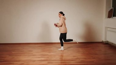 Kadınlar akşamları boş dans salonlarında basit hareketler ve odaklanmış ifadelerle dans ederler.