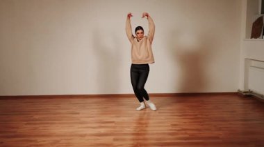 Kadınlar sıradan bir antrenman sırasında dans pistinde neşeyle dans ederler.