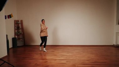Dans salonunda dans eden bir kadın basit hareketler ve etkileyici hareketlerle