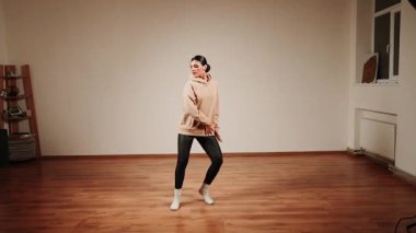 Dans salonunda dans eden kadın, kapalı oturum sırasında hareket ve ritme odaklanıyor.