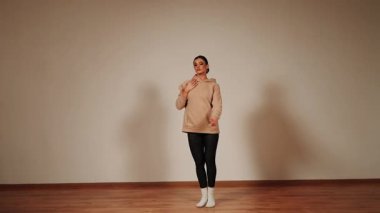 Bir dans salonunda tek başına dans eden bir kadın.