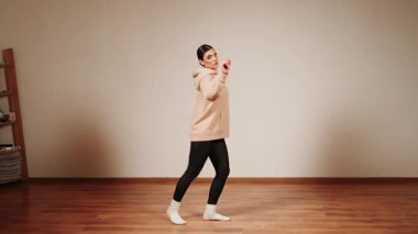 Dans salonundaki kadınlar antrenman sırasında kapüşonlu ve çoraplı dans ediyorlar.