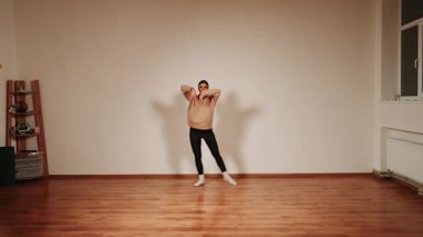 Akşam antrenmanı sırasında dans salonunda tek başına dans eden bir kadın.