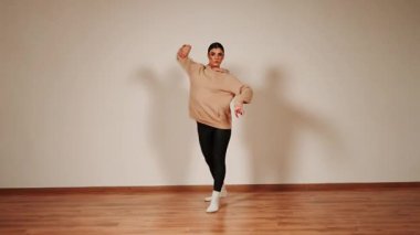 Gece dans pistinde dans eden bir kadın. Parlak ışıklar ve basit bir ortam.