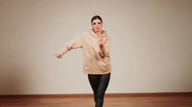 Dans salonunda dans eden bir kadın, hareketleriyle neşe ve enerjisini ifade eder.