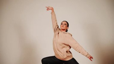 Akşam antrenmanı sırasında bir kadın dans salonunda enerjiyle dans ediyor.