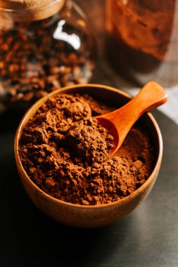 Mutfak masasında kaşıkla ahşap bir kasede kakao tozu.